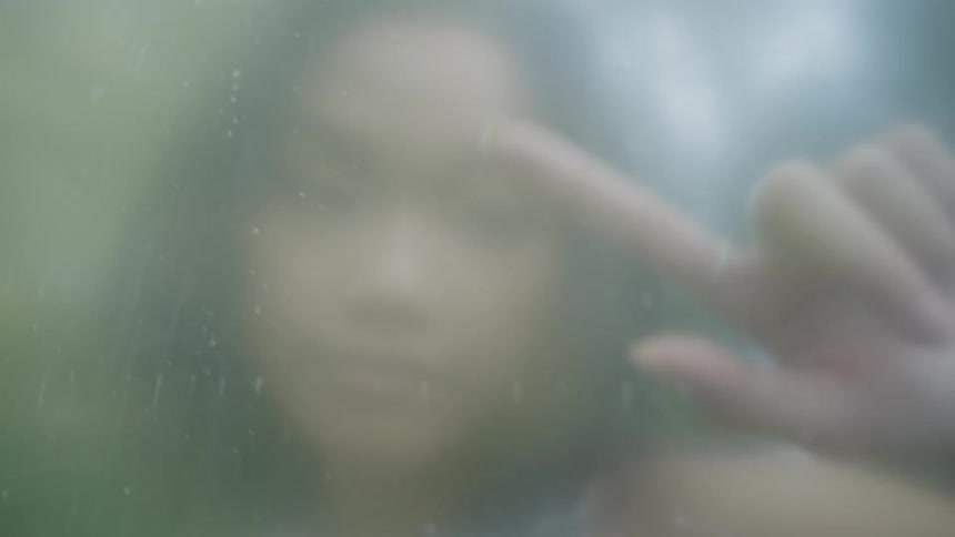Closeup of a woman pressing her fingers against an opaque glass pane