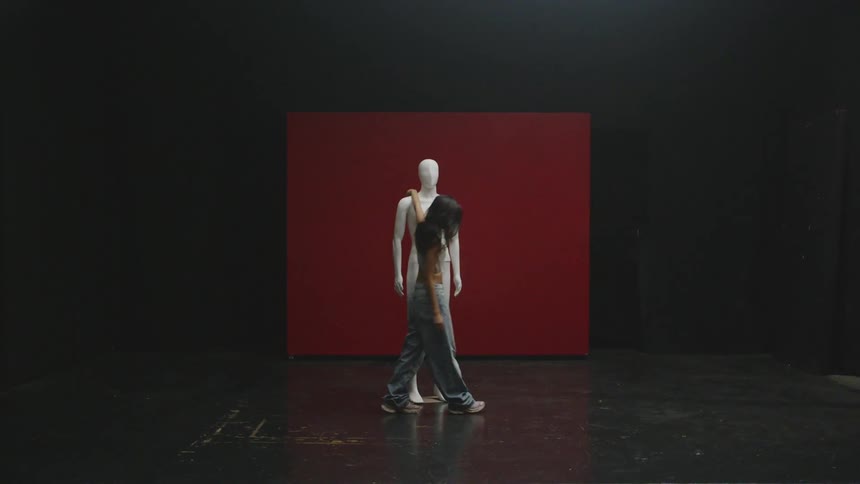 Woman in jeans walking around a mannequin in a studio