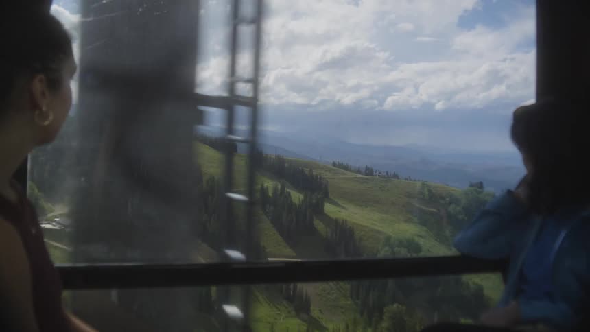 Two women talk while riding in the sky lift