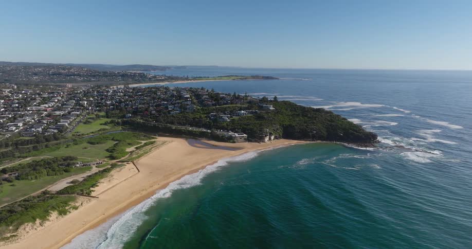 The beach curved gently around the coastline meeting the turquoise ocean