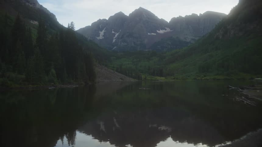 A serene lake reflects the majestic peaks of a mountain range