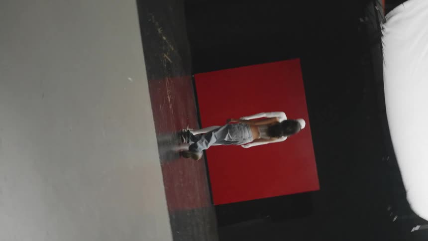 Woman walking towards a mannequin in a studio