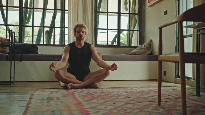 Man sitting with eyes closed in yoga position