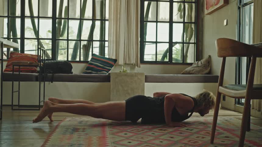 Man on living room rug doing yoga body stretches