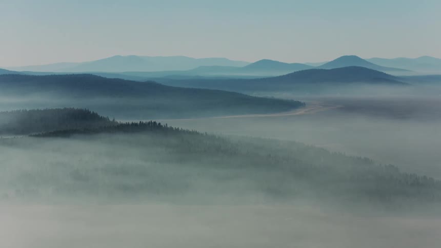Aerial panorama of a vast expanse of mountains in fog