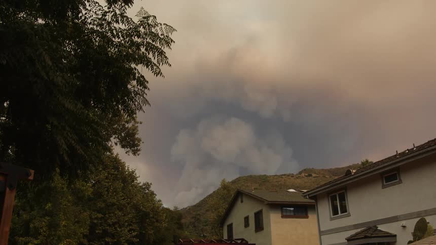 Smoke is rising from a wild fire near the neighborhood