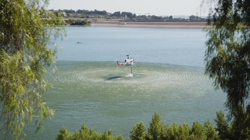 Helicopter hovers over a lake creating ripples on the surface