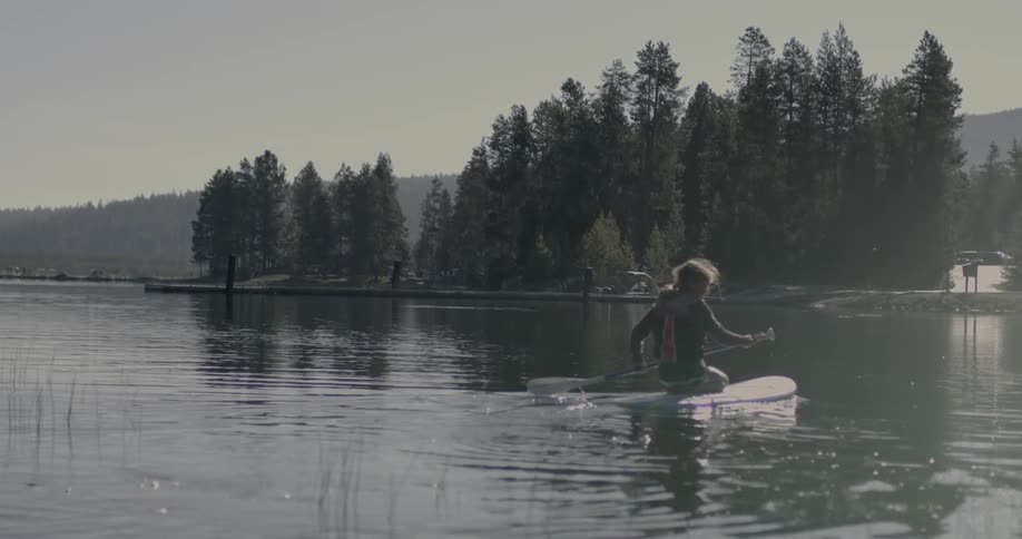 A woman paddles out into the water