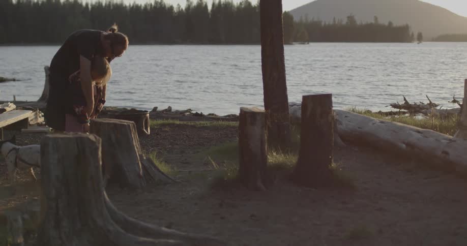 A man and child stand together by the shore