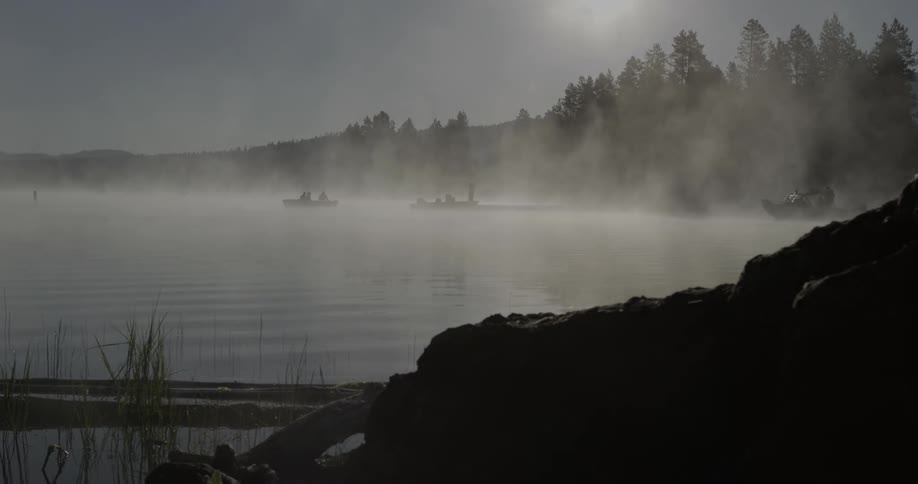 Boaters travel on a foggy lake