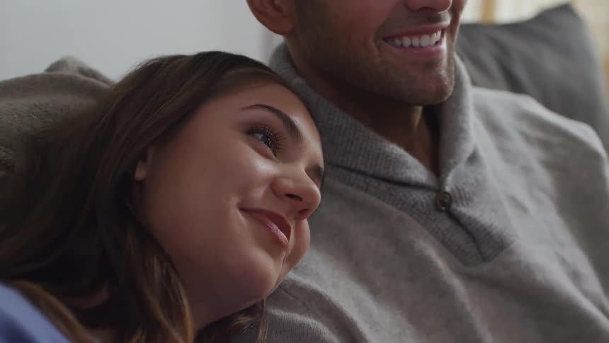 A woman is leaning her head on the shoulder of a smiling man