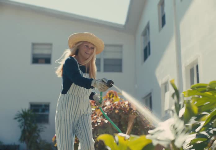 A woman is watering her plants