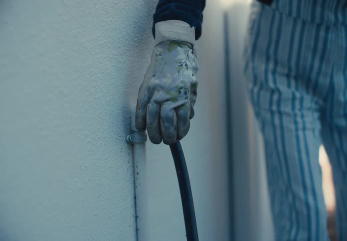 A woman turns on her hose with a lever
