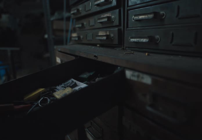 Hand pulling a drawer and picking up objects