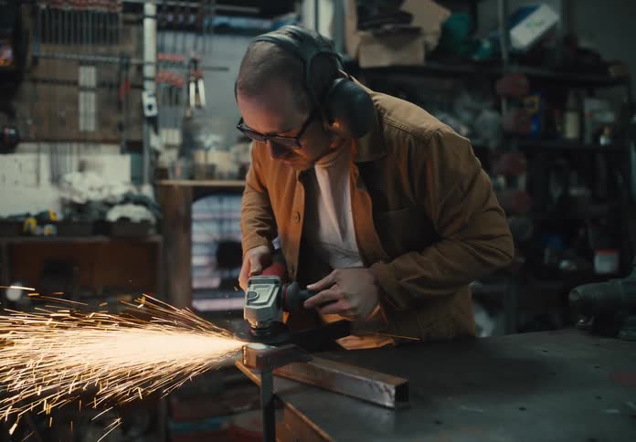 Welder sharpening a metal part and making sparks come out