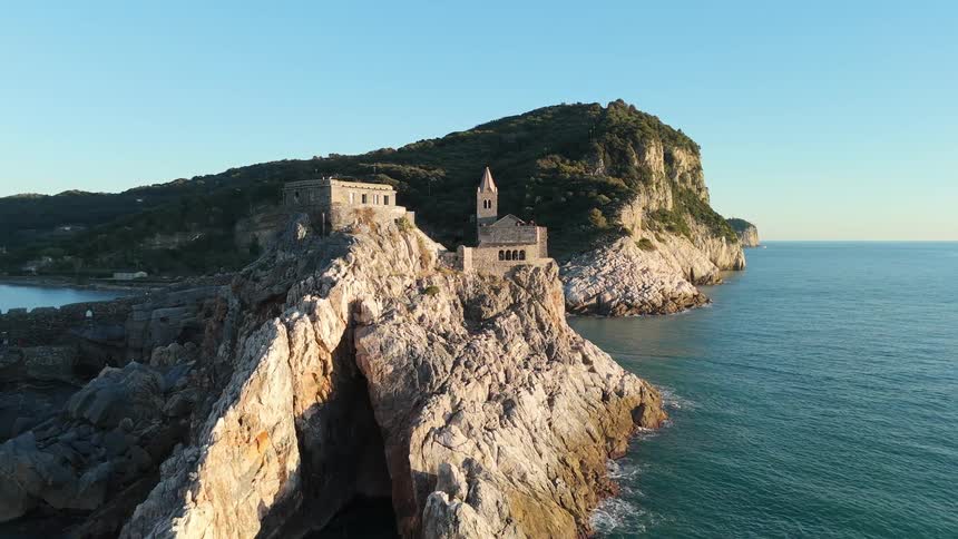 Birds fly by the monastery built on the rocks of the island