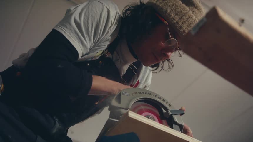 A man is cutting lumber with a circular saw