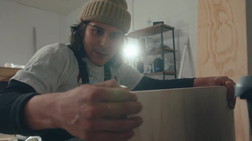 Carpenter man checking a wooden board in an indoor space