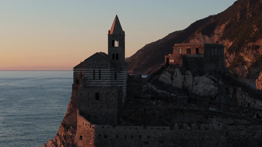 People walking at the church of san pietro in portovenere on the rocks overlooking the sea