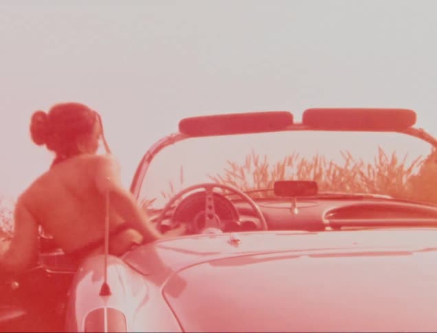 Man opening door for woman to sit inside classic car