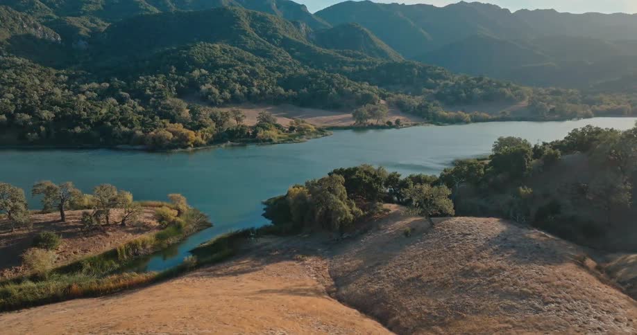 Aerial of a river that runs through forested hills and mountains