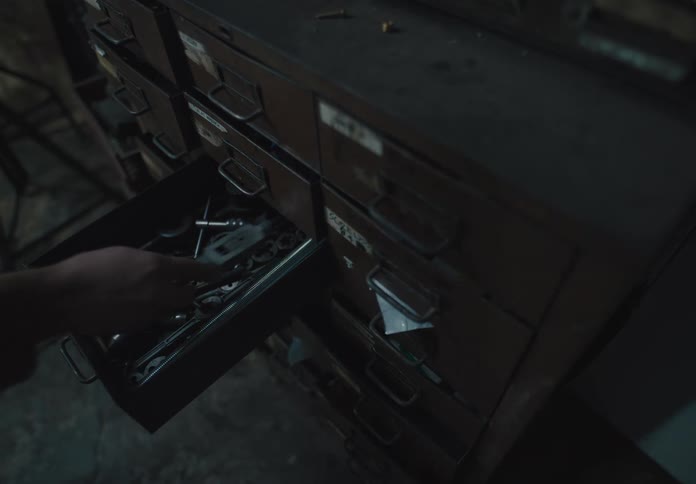 Hand opening a drawer and putting away a tool