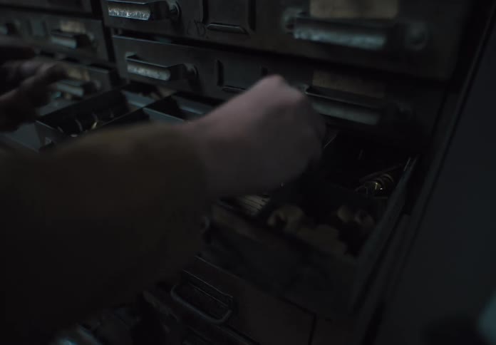Pair of hands opening a drawer and taking out some objects