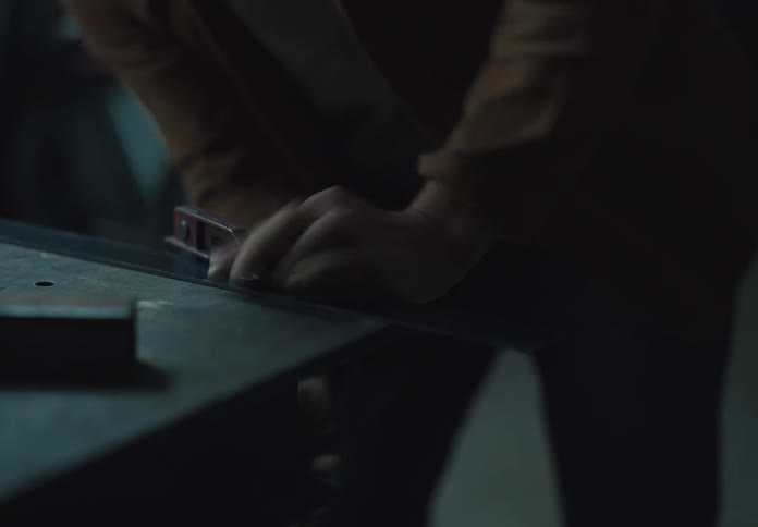 Person attaching a metal bracket to the corner of a table