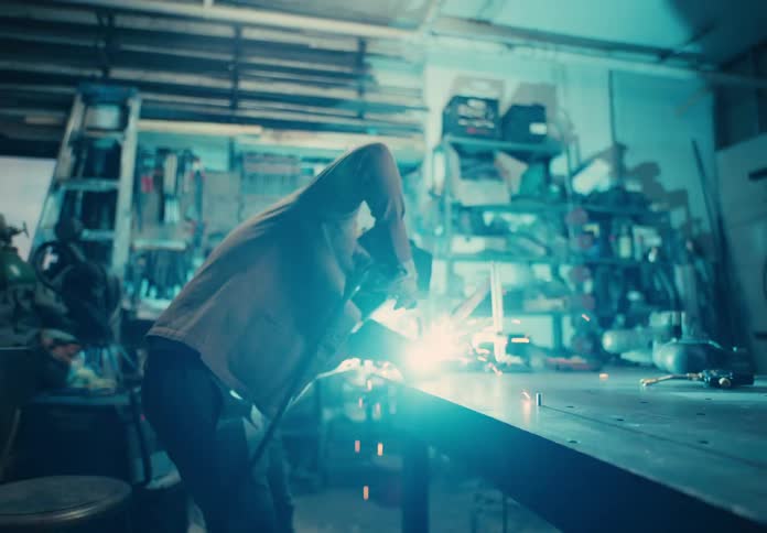 Man with protective helmet welding a metal