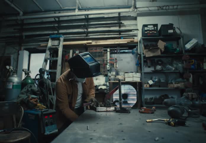 Mechanic man working indoors with a protective helmet