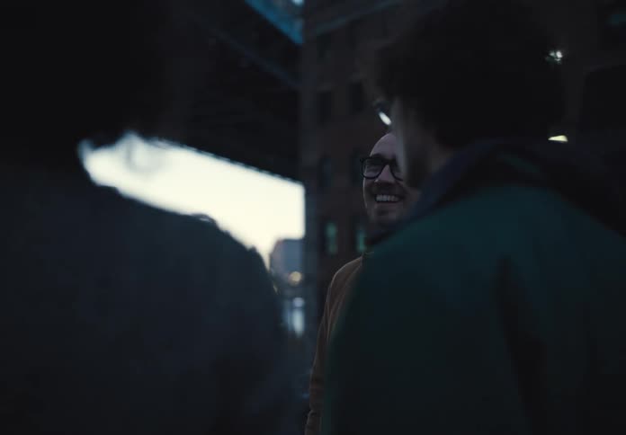 Three people on the city streets talking happily