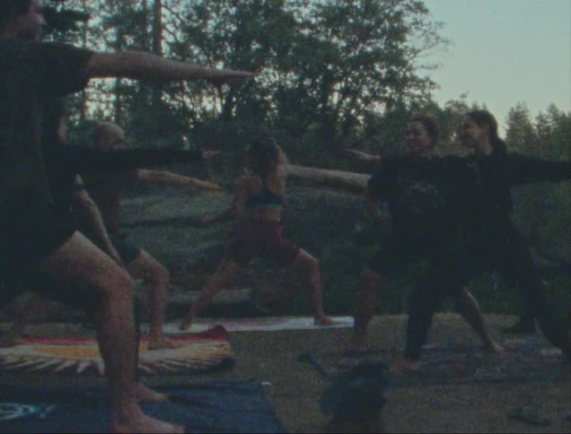 Group of people doing yoga outdoors in a forest
