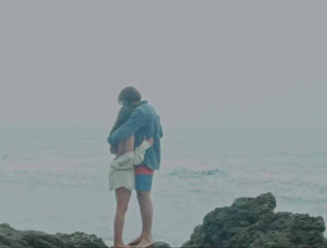 Couple hugging on rocks near the sea