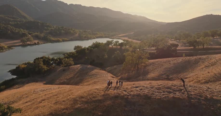 Aerial view of a group of people on a hill by a river