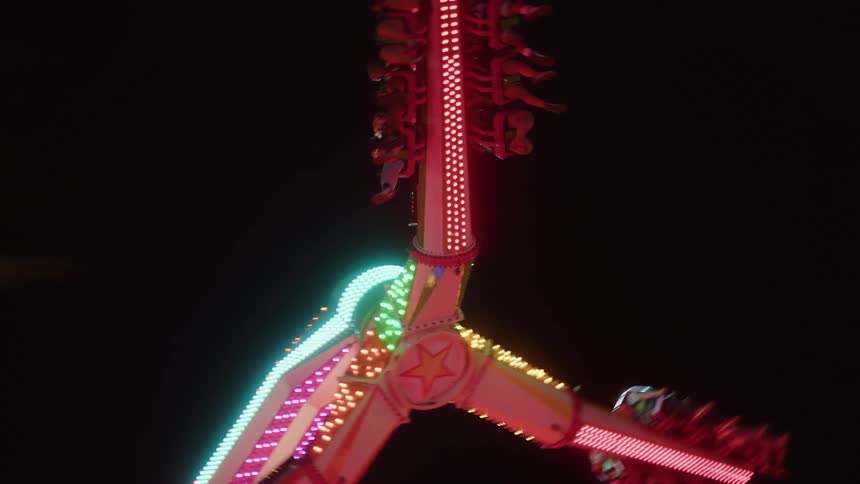 People playing in an amusement park with their legs suspended