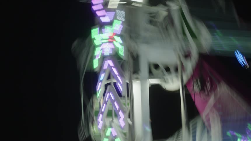 Upward view of a illuminated ferris wheel ride at night