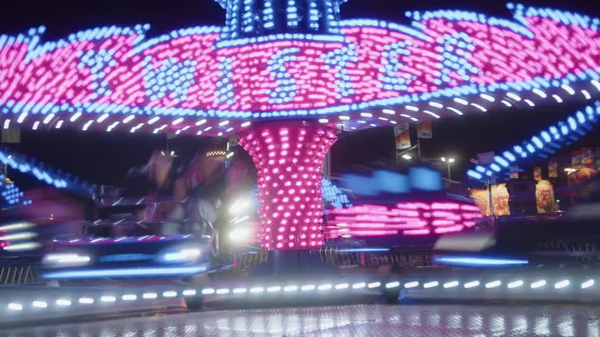 Neon light ride at an amusement park in operation at night