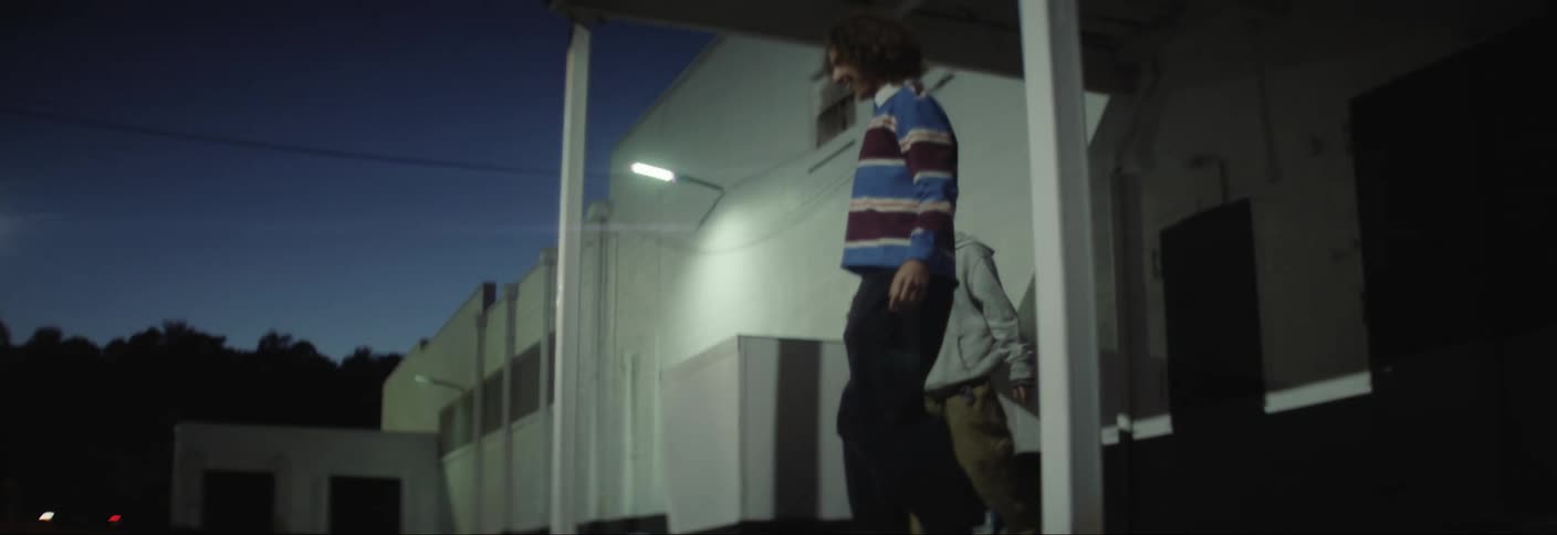 Teenagers looking down in an outdoor setting at night