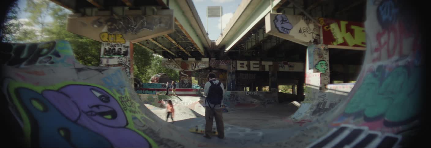 People are watching someone skateboard on the ramps