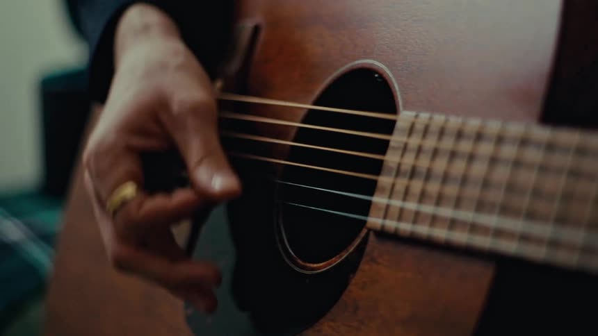 Close up of a persons hand playing guitar