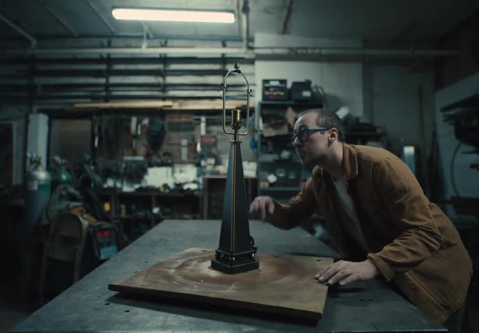 Man looking at an abstract object on a workshop table
