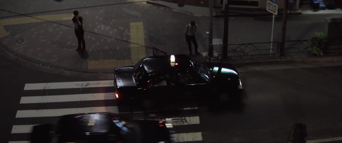 Passenger gets into a taxi stopped on a crosswalk at night