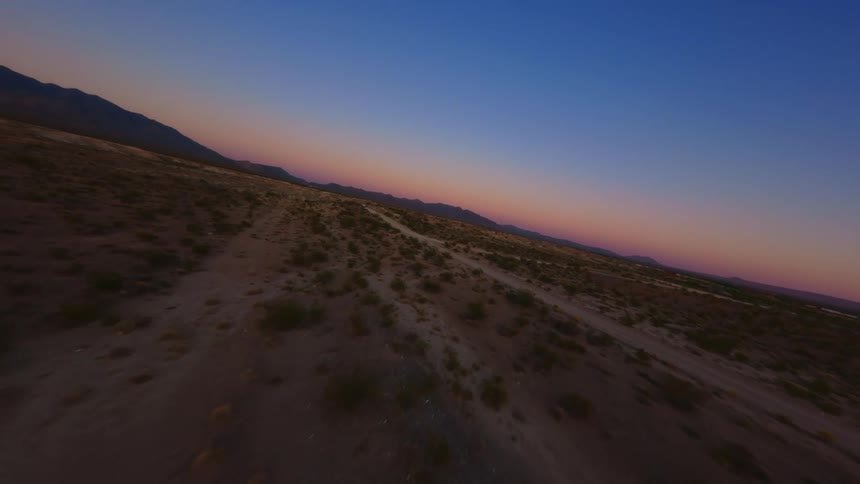 The sun is setting on the trail running through the landscape