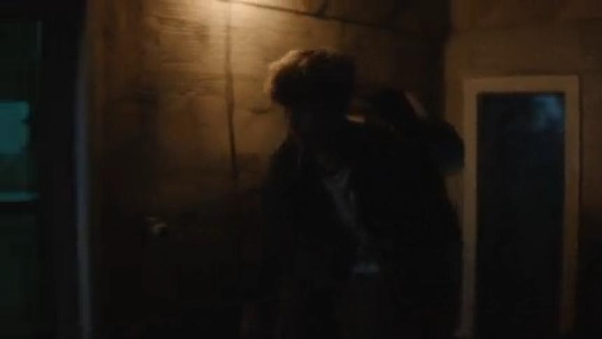Silhouette of a young man walking down an alley at night
