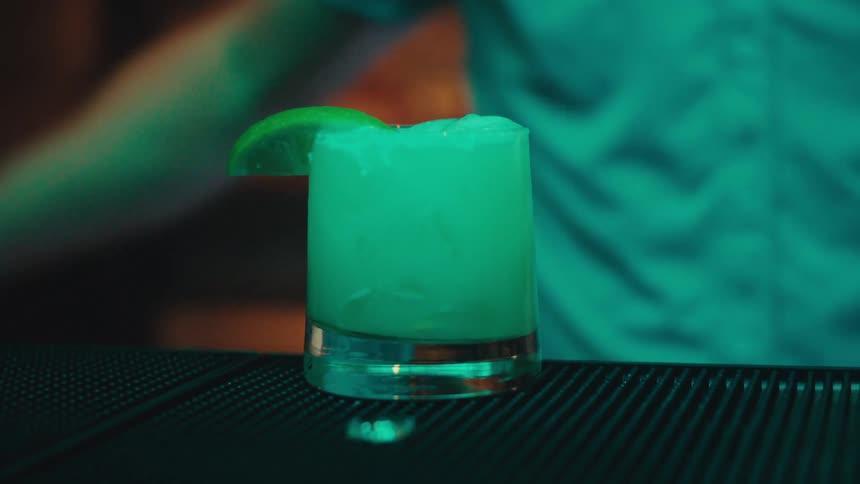 A man serves a drink with a straw