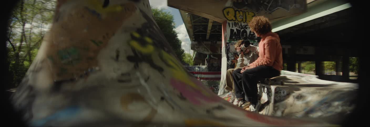 Person with a professional camera filming a boy sitting next to him