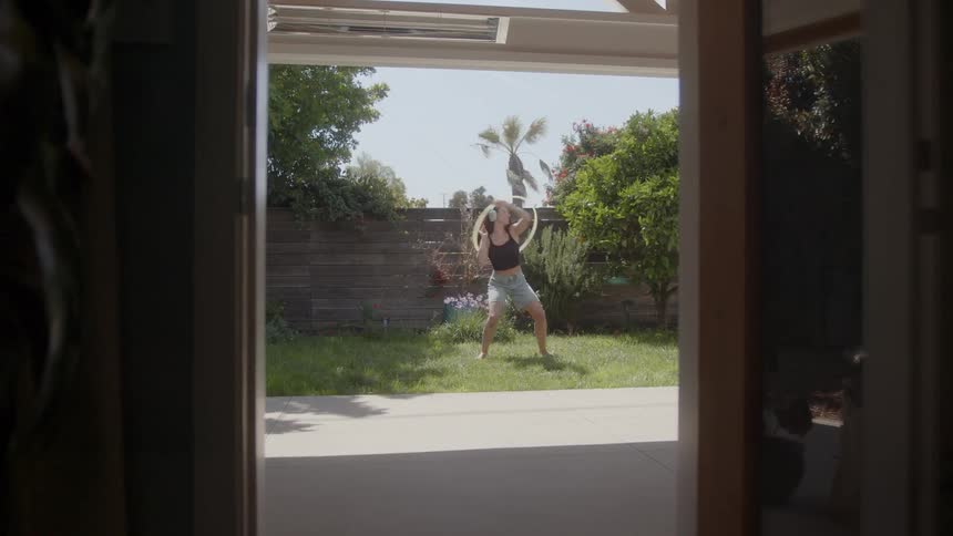 A woman is playing with a hula hoop outside