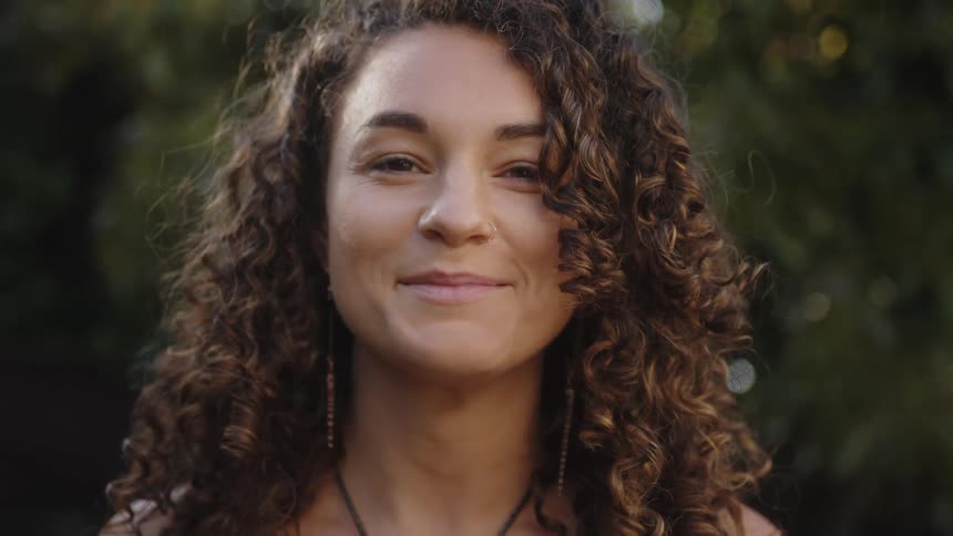 Portrait of a young curlyhaired woman outdoors
