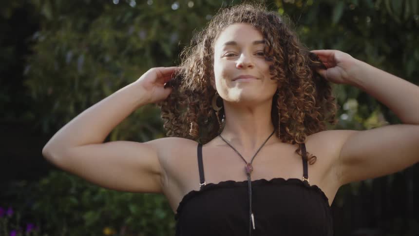 A woman is smiling in the yard