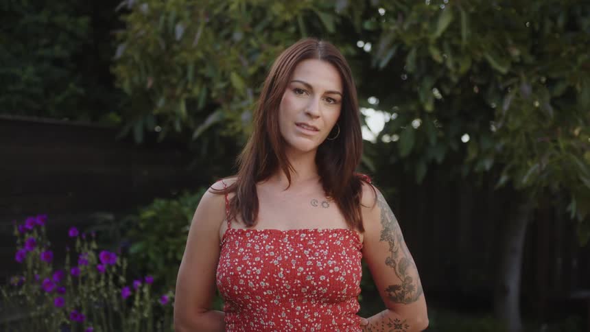 Woman in red floral dress in a backyard